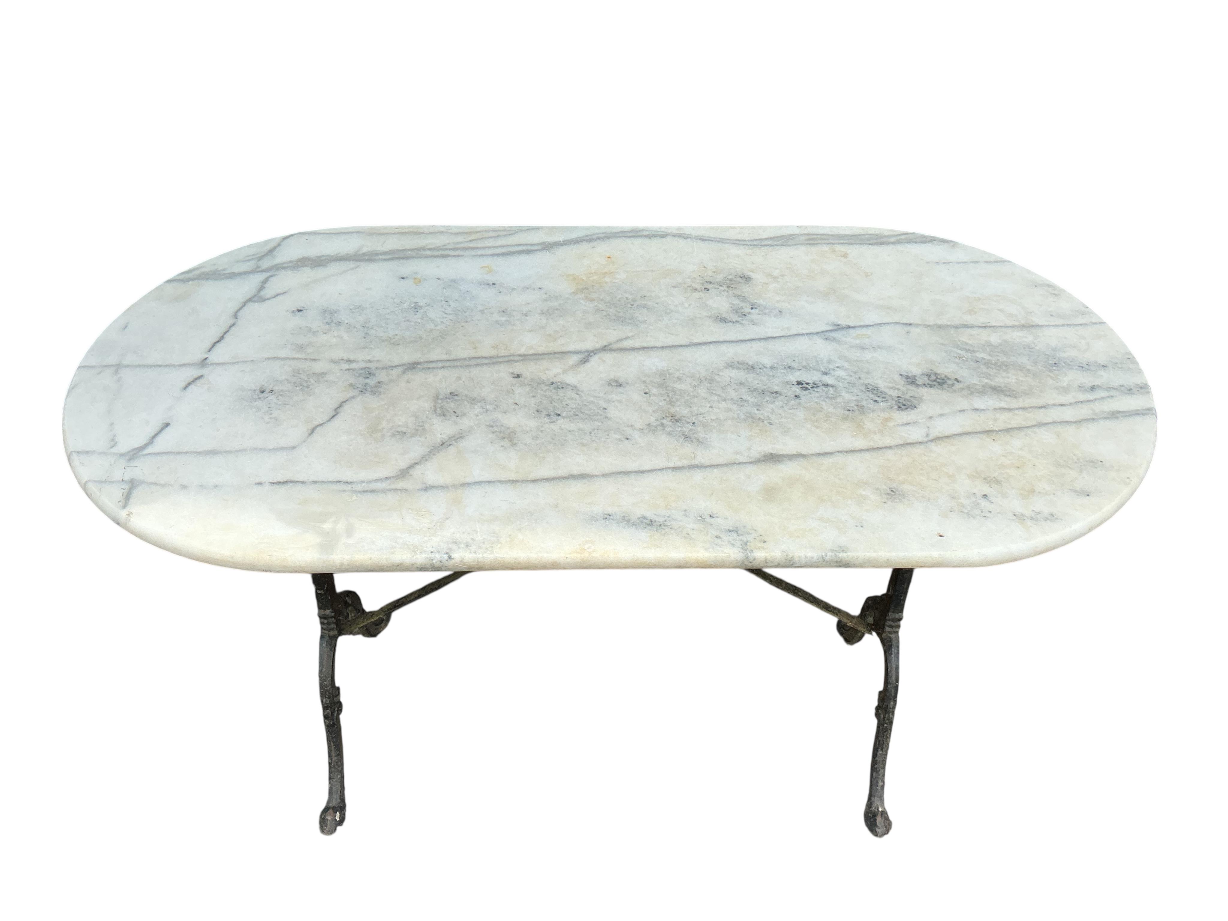 An oval reconstituted marble and cast iron garden table, width 120cm, depth 60cm, height 71cm